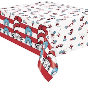 May include: A rectangular tablecloth featuring a white background with a repeating pattern of red and white striped hats, blue-haired characters, and red kites. The border displays horizontal red stripes alternating with the character and hat motifs.
