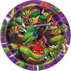 May include: Round paper plate featuring the Teenage Mutant Ninja Turtles. The plate has a purple brick wall background with green and white lightning bolt designs. The turtles are in action poses, each with their signature weapons.