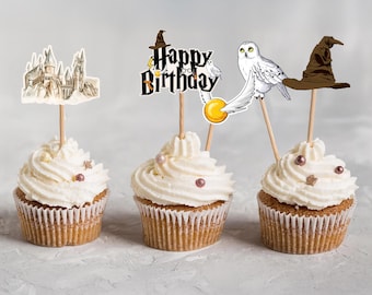 May include: Three cupcakes with white frosting and decorative toppers. The toppers feature a castle, a "Happy Birthday" sign, a white owl, a golden snitch, and a brown wizard hat. Each cupcake is decorated with small, pink pearl sprinkles.