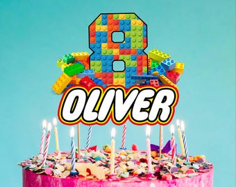 May include: A pink birthday cake with colorful sprinkles and lit candles. A topper made of toy blocks forms the number 8, with the name "OLIVER" in bold letters below. The background is a solid light blue.