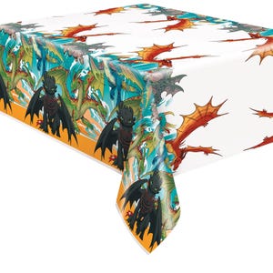 May include: White rectangular tablecloth featuring a repeating pattern of colorful dragons. The dragons are depicted in various colors, including black, green, red, and blue, with orange and teal accents. The tablecloth is designed for a party or event.