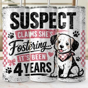Peut inclure: Gobelet blanc avec un motif vieilli portant l'inscription "SUSPECT CLAIMS SHE'S Fostering... IT'S BEEN 4 YEARS". Comprend un dessin de chien avec un bandana, des empreintes de pattes et un nœud rose. Le gobelet a une paille.
