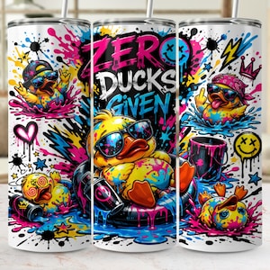 May include: A white tumbler with a vibrant graffiti-style design featuring cartoon ducks wearing sunglasses. The text "ZERO DUCKS GIVEN" is prominently displayed. The design includes colorful paint splatters, stars, and a smiley face.