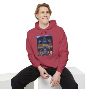 Peut inclure: Un sweat à capuche rouge avec un motif de maison hantée et le texte "WONDERFUL WORLD OF BONE". Le motif est centré. Le sweat à capuche a une capuche à cordon et une poche kangourou.