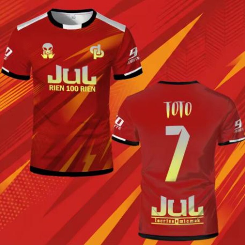 May include: A red short-sleeved t-shirt featuring a graphic print with the text JUL RIEN 100 RIEN on the front and the name TOTO with the number 7 and the text JUL on the back. The design includes an alien icon, a logo, and white accents.