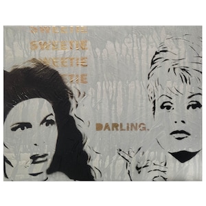May include: A rectangular canvas painting featuring two black and white stenciled portraits of women on a light gray background with vertical paint drips. The word SWEETIE is repeated in gold, and the word DARLING. is printed in gold.