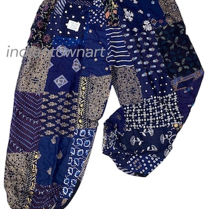 Puede incluir: Pantalones patchwork en tonos azules, dorados y morados. Los pantalones presentan una variedad de parches de tela estampada, incluyendo diseños florales, geométricos y paisley. La cintura es elástica con cordón. Los pantalones están hechos de un material ligero.