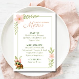 May include: A menu card with a floral design and the text "TURTLY ADORABLE Menu". The menu lists starters, main courses, and desserts. A cartoon turtle with a pink bow is at the bottom left corner. The card is on a white plate with a pink napkin.