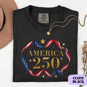 Bold gold glitter style America 250 typography framed with flowing USA flag ribbon and stars. Printed on soft premium cotton tees for adults, youth and toddlers. Unisex relaxed fit, breathable and durable for all day comfort. Ideal for Independence Day, patriotic parades, fireworks nights, family matching outfits, USA 250 celebrations and summer events.