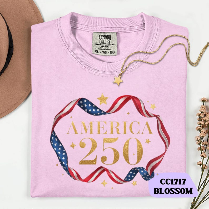 Bold gold glitter style America 250 typography framed with flowing USA flag ribbon and stars. Printed on soft premium cotton tees for adults, youth and toddlers. Unisex relaxed fit, breathable and durable for all day comfort. Ideal for Independence Day, patriotic parades, fireworks nights, family matching outfits, USA 250 celebrations and summer events.