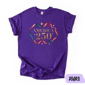 Bold gold glitter style America 250 typography framed with flowing USA flag ribbon and stars. Printed on soft premium cotton tees for adults, youth and toddlers. Unisex relaxed fit, breathable and durable for all day comfort. Ideal for Independence Day, patriotic parades, fireworks nights, family matching outfits, USA 250 celebrations and summer events.