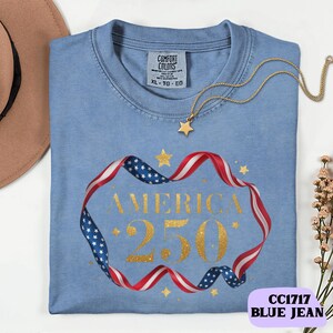 Bold gold glitter style America 250 typography framed with flowing USA flag ribbon and stars. Printed on soft premium cotton tees for adults, youth and toddlers. Unisex relaxed fit, breathable and durable for all day comfort. Ideal for Independence Day, patriotic parades, fireworks nights, family matching outfits, USA 250 celebrations and summer events.