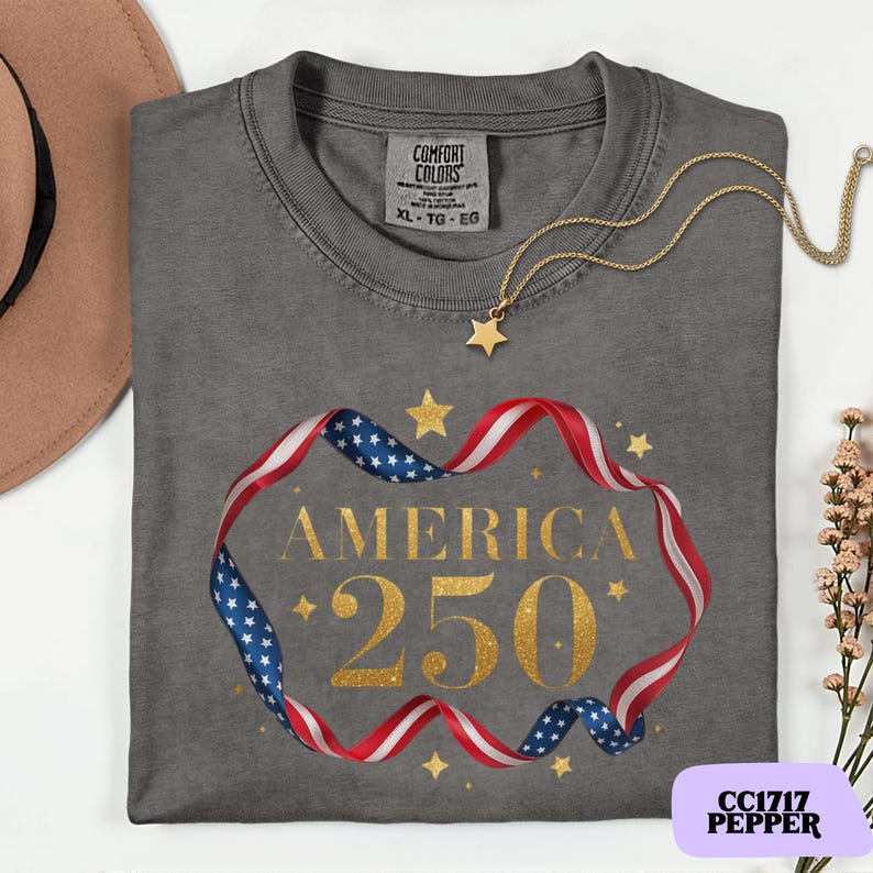 Bold gold glitter style America 250 typography framed with flowing USA flag ribbon and stars. Printed on soft premium cotton tees for adults, youth and toddlers. Unisex relaxed fit, breathable and durable for all day comfort. Ideal for Independence Day, patriotic parades, fireworks nights, family matching outfits, USA 250 celebrations and summer events.