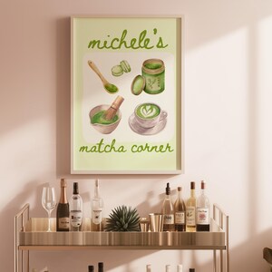 Peut inclure: Une affiche encadr&eacute;e intitul&eacute;e "Michele's Matcha Corner" avec des illustrations &agrave; l'aquarelle de la pr&eacute;paration du th&eacute; matcha. L'&oelig;uvre comprend une cuill&egrave;re en bois, un fouet, un bol, une tasse et un pot de poudre de matcha, le tout dans des tons verts.