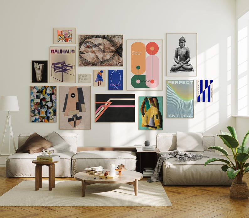 May include: A gallery wall featuring various framed art prints in a living room setting. The artwork includes abstract designs, geometric shapes, and a Buddha statue. The color palette includes beige, black, blue, and orange.