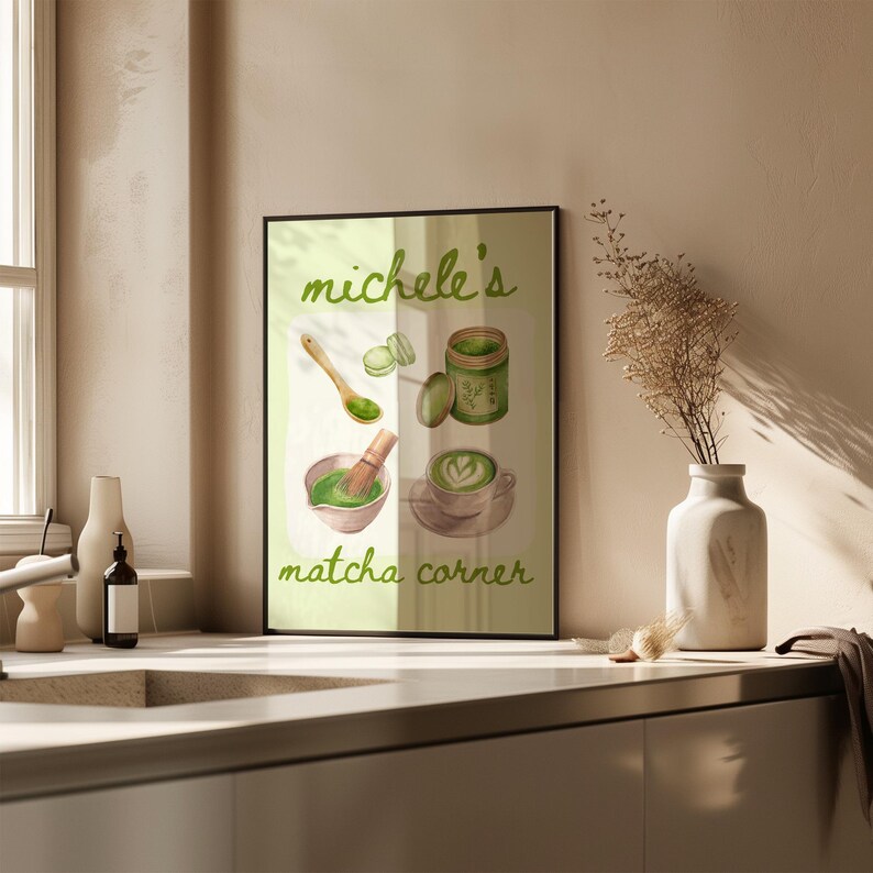 Peut inclure: Une affiche encadr&eacute;e avec des illustrations sur le th&egrave;me du matcha. L'&oelig;uvre comprend un bol &agrave; matcha avec un fouet, une tasse de latte matcha, un pot de poudre de matcha et le texte "Michele's matcha corner" en &eacute;criture verte.