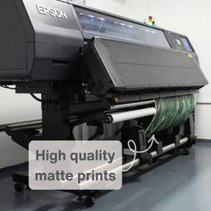 Peut inclure: Une grande imprimante Epson noire avec un rouleau de mat&eacute;riel imprim&eacute;. Le texte "High quality matte prints" est superpos&eacute; &agrave; l'image. L'imprimante est sur un support &agrave; roulettes dans une pi&egrave;ce lumineuse.