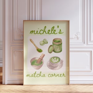 Peut inclure: Une affiche encadr&eacute;e avec des illustrations sur le th&egrave;me du matcha. L'affiche comprend une cuill&egrave;re en bois, des macarons, un pot de matcha, un fouet, un bol de matcha et une tasse de latte au matcha. Le texte "Michele's matcha corner" est &eacute;crit en vert.