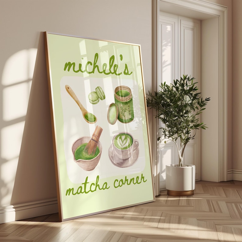 Peut inclure: Une affiche encadr&eacute;e avec des illustrations sur le th&egrave;me du matcha. Elle pr&eacute;sente un bol avec un fouet, une tasse de latte au matcha, des macarons et un pot de poudre de matcha. Le texte "Michele's matcha corner" est en vert.