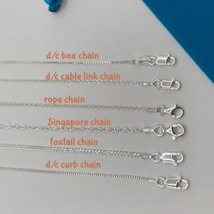 Peut inclure: Présentation de colliers chaîne en argent, comprenant des modèles box, câble, corde, Singapore, queue de renard et gourmette. Chaque chaîne est présentée avec son fermoir et étiquetée sur fond clair.