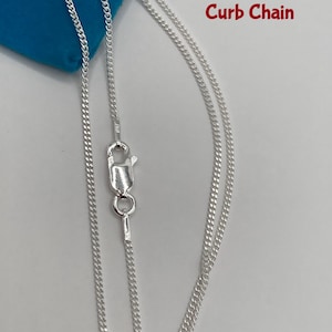 May include: A silver curb chain necklace with a lobster clasp. The chain is displayed against a blue background. The words "Curb Chain" are written in red.