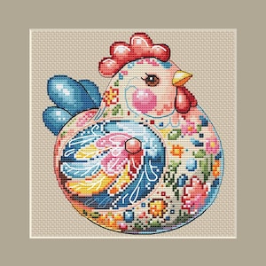 May include: A colorful cross-stitch design of a chicken. The chicken features a red comb and wattle, blue wings, and a body adorned with floral patterns in pink, yellow, and blue. The background is a neutral beige.