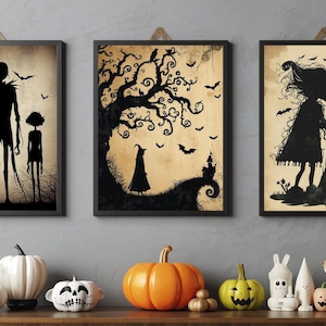 Puede incluir: Tres impresiones artísticas enmarcadas con temática de Halloween con siluetas negras sobre un fondo sepia. Las impresiones representan figuras espeluznantes, árboles y murciélagos. Debajo, una estantería de madera exhibe varias decoraciones de Halloween.