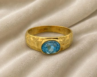 Gouden ring met blauwe topaas, gehamerde gouden bandring, minimalistische edelsteenring, geboortesteen december, handgemaakte gouden sieraden, stapelbare ring
