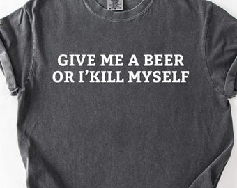 May include: Dark gray t-shirt with the text "GIVE ME A BEER OR I'KILL MYSELF" in white block letters. The shirt has a crew neck and short sleeves. The fabric appears to be pre-washed for a vintage look.