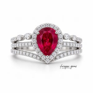Pode incluir: Um conjunto de três anéis com uma pedra vermelha escura em forma de pêra, rodeada por pedras claras menores. O conjunto inclui duas bandas adicionais, tudo em metal prateado. O texto "furgan gems" é visível.