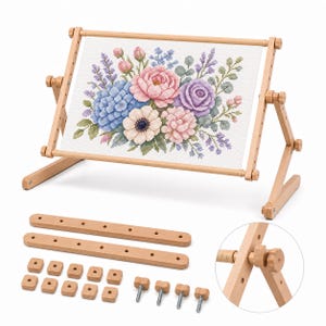 May include: A light-colored wooden embroidery frame holding a white fabric panel with a cross-stitch floral bouquet in pink, blue, and purple. Below are two wooden bars, ten square wooden nuts, and four metal bolts with wooden knobs for assembly.