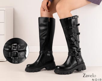 May include: Black knee-high boots with multiple buckles and a chunky sole. The boots have a zip on the side and studded details around the ankle. The brand name "Zavelo Noir" is visible in the bottom right corner.