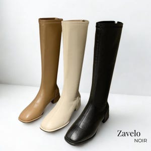 May include: Three knee-high boots in tan, cream, and black. Each boot has a square toe and a low block heel. The black boot has a zipper on the side. The boots are displayed on a white surface. The text "Zavelo NOIR" is in the bottom right corner.