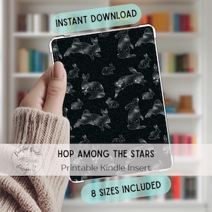 Puede incluir: Una funda Kindle negra con un patrón de conejos blancos sobre un fondo estrellado. El texto "INSTANT DOWNLOAD" está en la parte superior, y "HOP AMONG THE STARS Printable Kindle Insert" está en el medio. El texto inferior dice "8 SIZES INCLUDED".