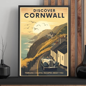 May include: A framed vintage travel poster with the words "DISCOVER CORNWALL" above a scenic illustration. The artwork depicts a coastal road with a classic car, seagulls, and a sunset over the ocean. Text at the bottom reads "TIMELESS COASTAL ESCAPES AWAIT YOU."