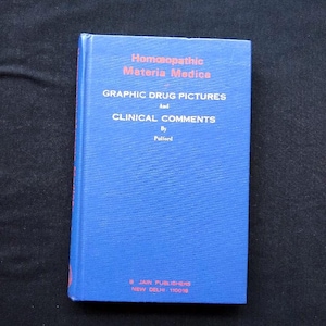 May include: A blue book titled "Homœopathic Materia Medica" with the subtitle "Graphic Drug Pictures and Clinical Comments." The book is by Pullord and published by Jain Publishers, New Delhi.