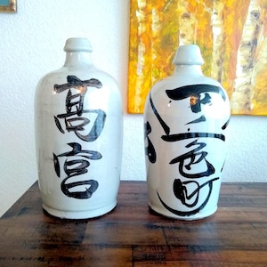 May include: A handcrafted wooden sign, painted white with a distressed finish, bearing the text "Welcome to our home" in a handwritten font. A small heart decorates the sign, suitable for indoor or outdoor display.