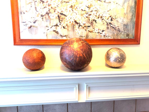 Signed brutalist metal orb set from a named artist — raw industrial texture meets gallery-worthy sculpture in a small-batch studio piece.