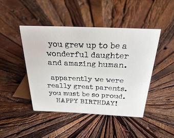 May include: A white rectangular greeting card with black typewriter-style text that reads: you grew up to be a wonderful daughter and amazing human. apparently we were really great parents. you must be so proud. HAPPY BIRTHDAY!