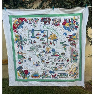 May include: A white square souvenir scarf featuring a colorful illustrated map of California. The map includes various landmarks, regional activities, and the text California in a central banner, all framed by a green border on a white background.