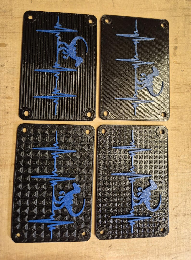 May include: Four black rectangular panels with a blue design. Each panel features a blue illustration of a monkey climbing a line, with a heartbeat-like pattern. The panels have rounded corners and holes for mounting.