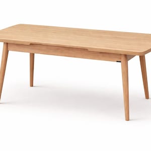 May include: A light-coloured wooden rectangular coffee table with rounded corners and four angled legs. The table has a simple, minimalist design, with a smooth surface and a small recessed area on the top. The table is approximately 120 cm long.
