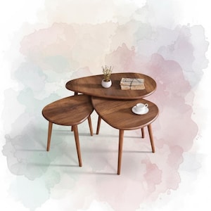 May include: A set of three wooden nesting tables with a warm brown finish. The tables have a unique, organic shape and tapered legs. A small white ceramic pot with dried flowers, a stack of books, and a teacup and saucer are on the tables.