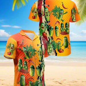 May include: Two short-sleeved button-down shirts with a vibrant orange background. The shirts feature a repeating pattern of cartoon pickles, tomatoes, and chili peppers. The shirts are displayed on a beach setting with palm trees and ocean in the background.