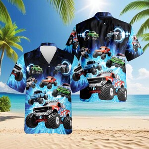 May include: Two short-sleeved button-down shirts with a vibrant monster truck design. The shirts feature a blue and black background with multiple monster trucks in various colors. The trucks have large tires and are set against a beach scene.