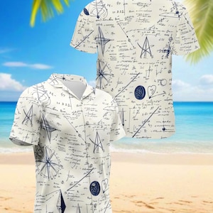 Può includere: Due camicie a maniche corte con bottoni, con sfondo color crema e un design a tema nautico blu navy. Il design include bussole, stelle e scritte a mano. Le camicie sono esposte su una spiaggia con palme e il mare sullo sfondo.