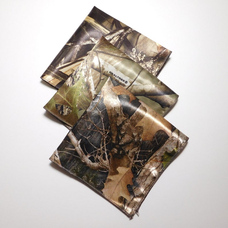 May include: Three camouflage fabric squares with the Realtree logo on one of the squares.