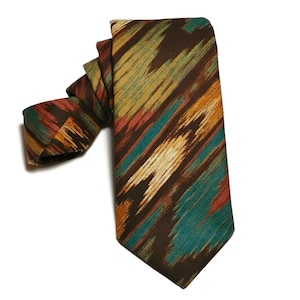 May include: A brown tie with a colorful abstract pattern in shades of teal, orange, red, and white.