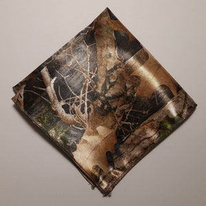 May include: A brown and green camouflage patterned pocket square. The fabric has a satin finish.