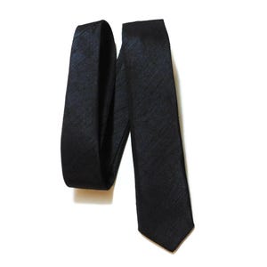 May include: A black silk tie with a subtle textured pattern.